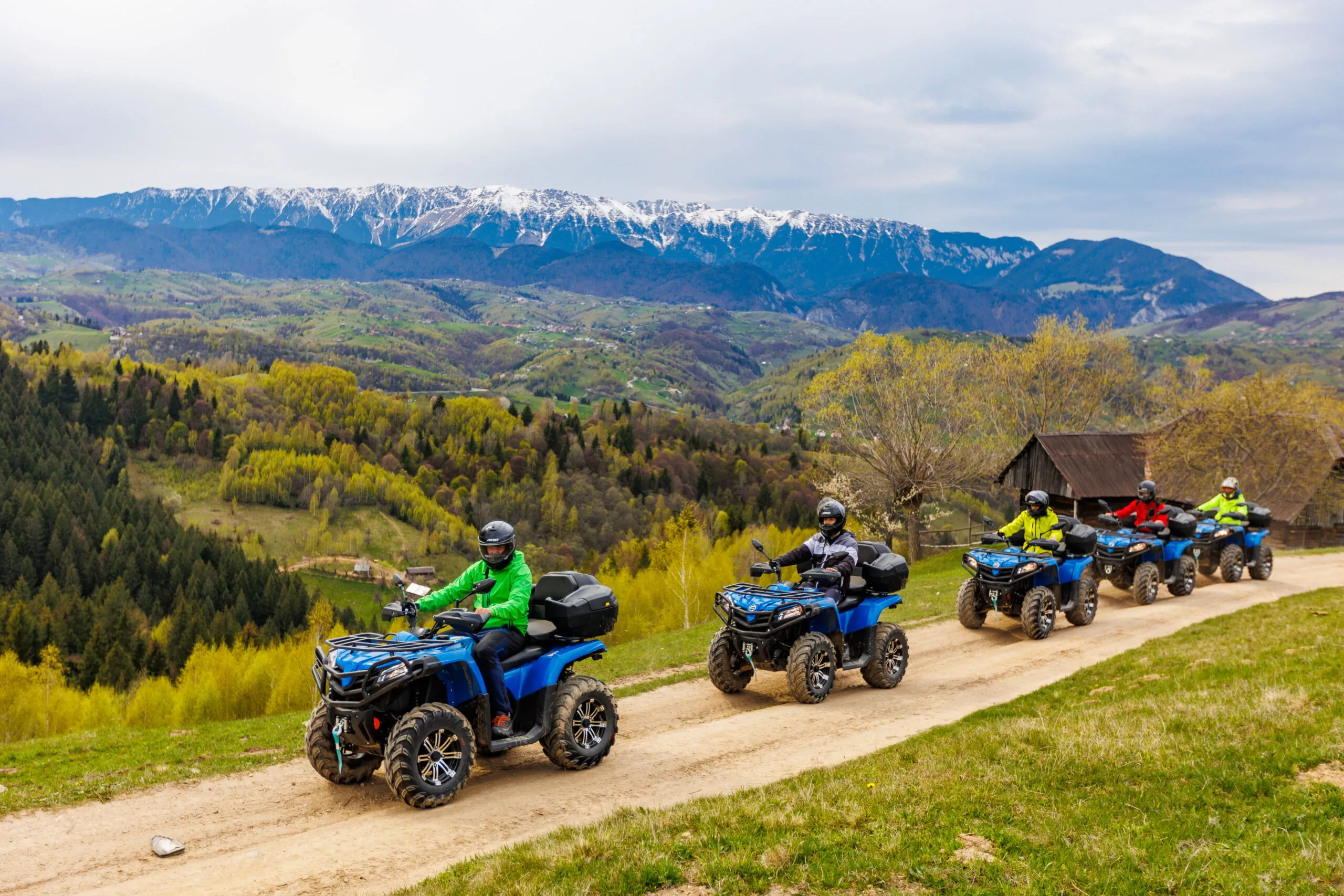 Grup de turiști pe ATV-uri în Bran, traseu montan cu priveliști spre Munții Bucegi și Piatra Craiului